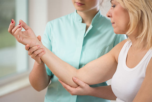 nurse helping patietn recover range of motion through therapy.